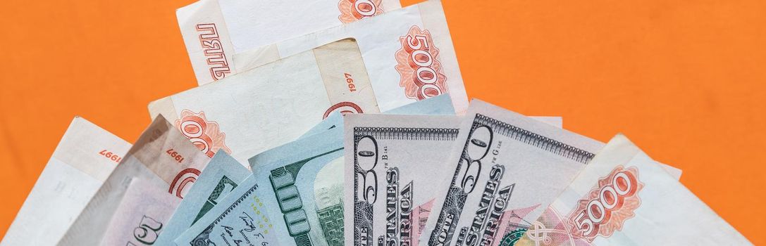 Russian rubles on background of US dollars. Concept of exchange rate, sanctions, falling ruble