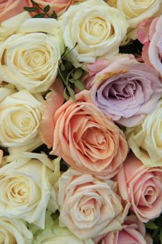 Pastel roses in various colors in a mixed wedding arrangement