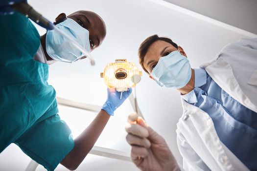Lets give you a smile that matches your style. Low angle shot of two dentists getting ready to perform a procedure on a patient
