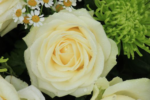 White wedding roses in a floral wedding decoration with some green