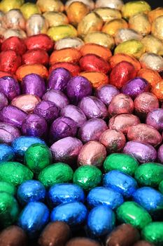 a group of foil wrapped chocolate easter eggs in rainbow colors