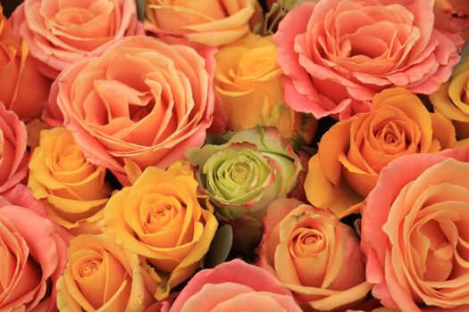 Yellow, orange and pink roses in a floral arrangement at a wedding