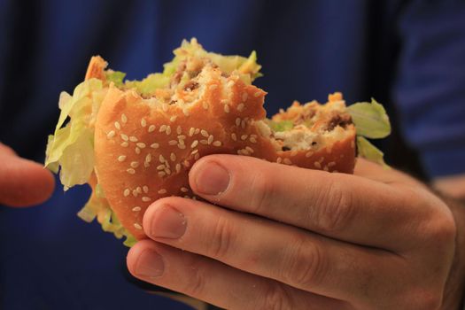 Man holding a fresh made hamburger