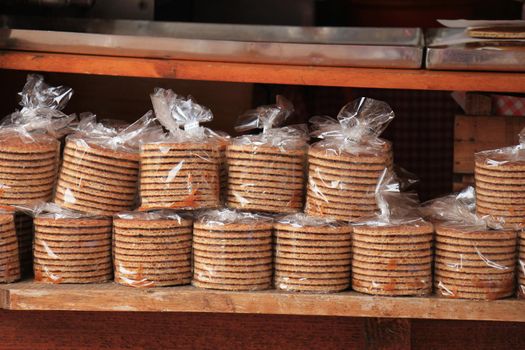 Traditional Dutch stroopwafels, a traditional sweet cookie, filled with caramel syrup. These are wrapped in plastic to keep them soft. Text in the small closing clip is the "best before" date