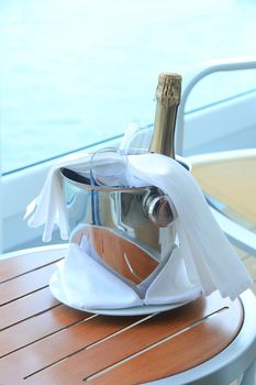 A bottle of champagne and glasses, waiting in a bucket to be served