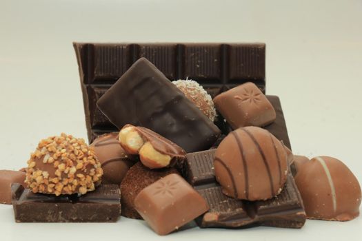 Different sorts of chocolates: bonbons and broken pieces of a chocolate bar