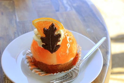 Fresh orange mousse confectionery, with cream and a chocolate decoration