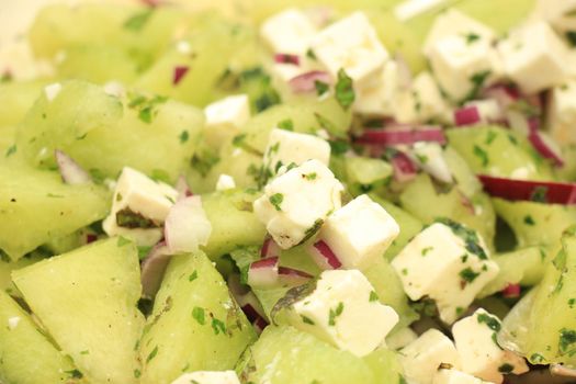 Green melon salad with soft white feta cheese and herbs