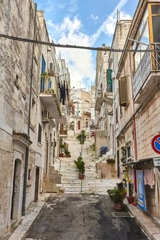 Amazing architecture of an old streets decorated with plants in flowerpots. Downtown, white city Ostuni, Bari, Italy. Tourism, travel concept.