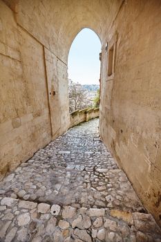 Scenic view of the age-old town of Matera - european capital of culture in 2019, Sassi district, southern Italy. Ancient arch of an old stone city, Unesco heritage site.