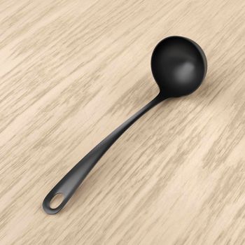 Black plastic ladle on wood background