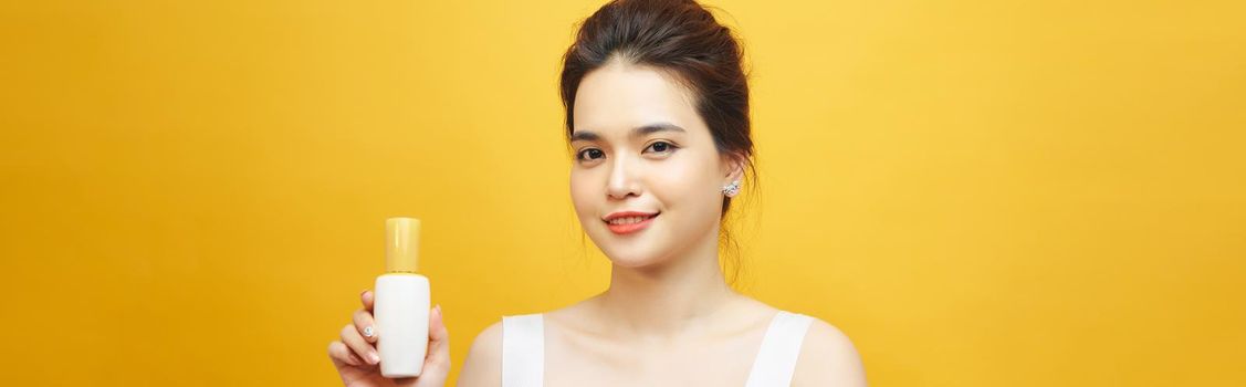 Asian young woman showing beauty product on hand
