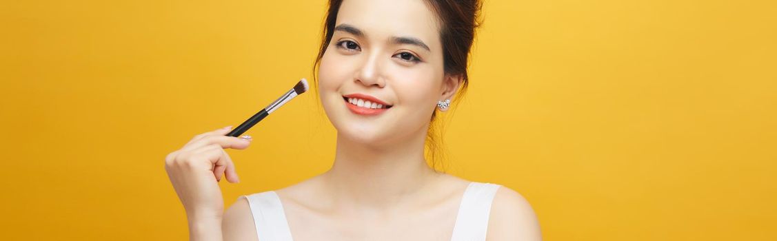 Woman applying make up with brush, isolated. Beauty procedures