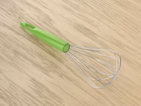 Metal balloon whisk on the wooden table