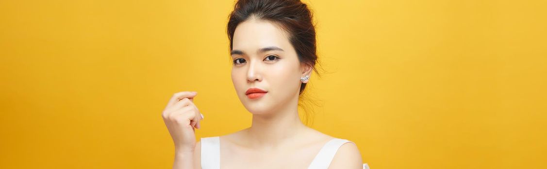 Fashion photo of a beautiful young woman in a pretty dress over white background.