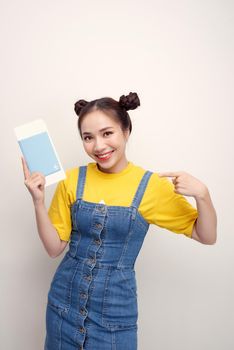 Attractive excited woman 20s smiling while holding passport with travel tickets isolated over white background