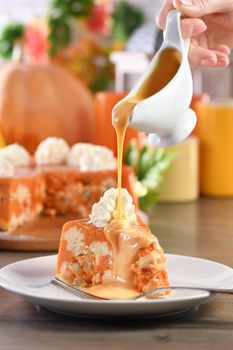 Slice of Pumpkin and cottage cheese casserole with caramel topping on a plate. This is a delicious dessert filled with autumnal notes. It is full of pumpkin spice aromas, creamy softness with raisins.