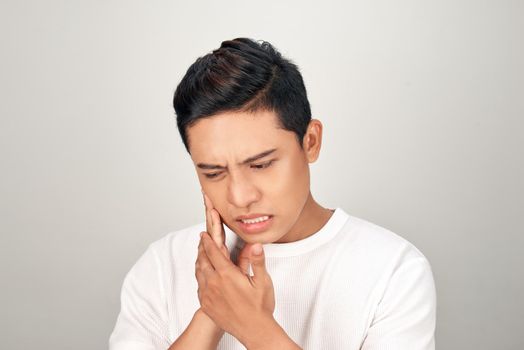 Portrait of Asian men with worry eyes use hand touching his cheek , feelings pain from toothache. Tooth and mouth disease concept.