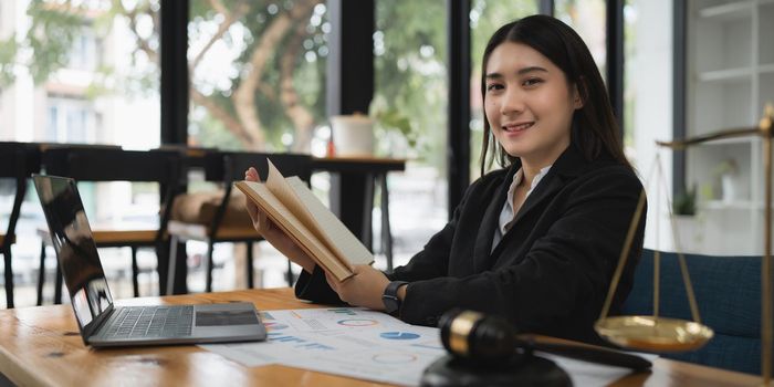 Lawyer business woman reading law book and agreement contract.