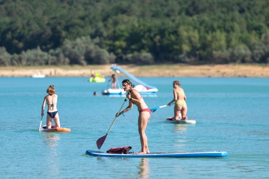 Montbel, France. 2022 August 2 . People practicing water sports on Lake Montbel in Ariege with the boats in the summer of 2022.
