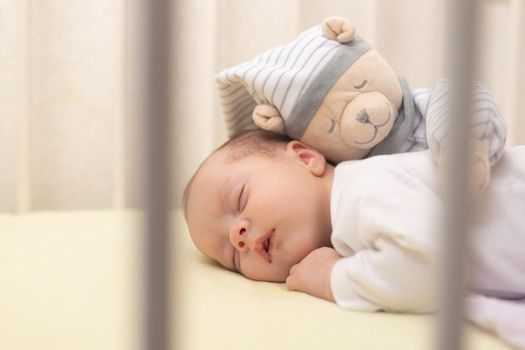 The baby sleeps in the copy space crib . Advertising of children's goods. Illustrating children's articles. A small child. A newborn. A child's dream.