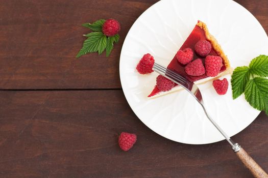 Raspberry pie (cheesecake) made from fresh raspberries with tea on a wooden background.Copy space