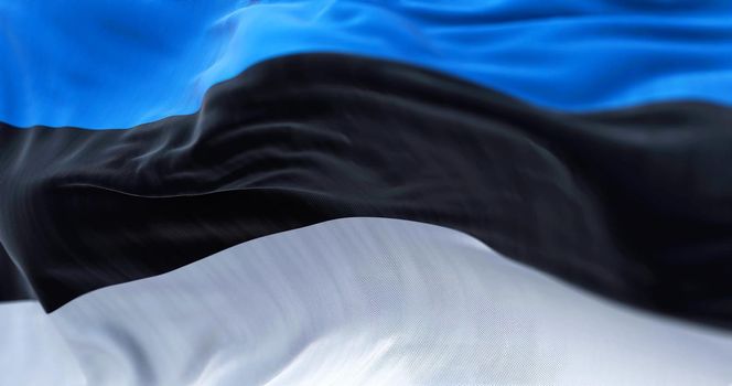 Close-up view of the estonian national flag waving in the wind. Estonia is a country in Northern Europe. Fabric textured background. Selective focus