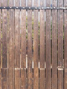 Fence made of vertical boards of natural wood in full screen