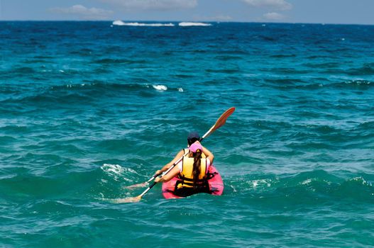  A guy and a girl row together with oars and swim in a kayak into the open sea.