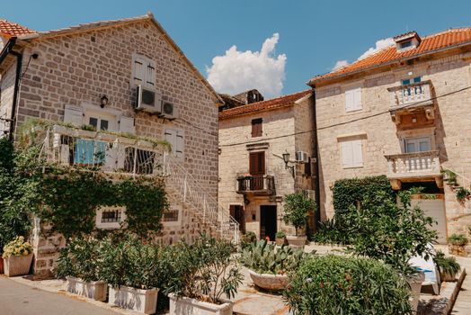 Historic city of Perast at Bay of Kotor in summer, Montenegro. Scenic panorama view of the historic town of Perast at famous Bay of Kotor with blooming flowers on a beautiful sunny day with blue sky and clouds in summer, Montenegro, southern Europe