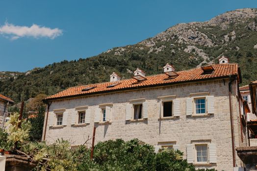 Historic city of Perast at Bay of Kotor in summer, Montenegro. Scenic panorama view of the historic town of Perast at famous Bay of Kotor with blooming flowers on a beautiful sunny day with blue sky and clouds in summer, Montenegro, southern Europe