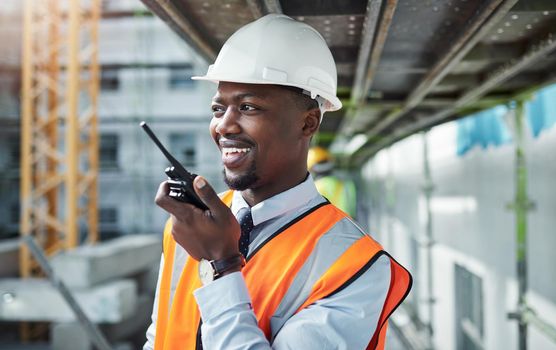 Communication carries a project from inception to completion. a young man using a walkie talkie while working at a construction site