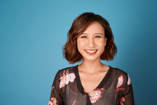 Chilling girl with short hairstyle standing in room on light blue background.