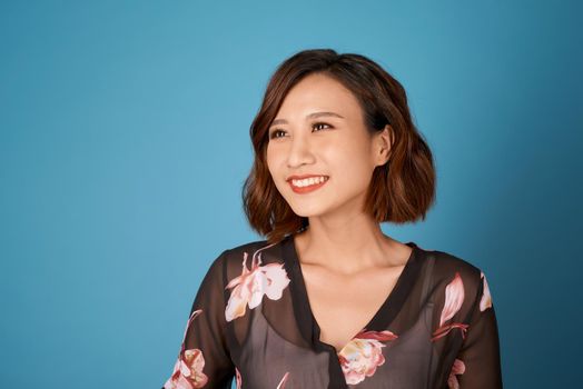 Chilling girl with short hairstyle standing in room on light blue background.