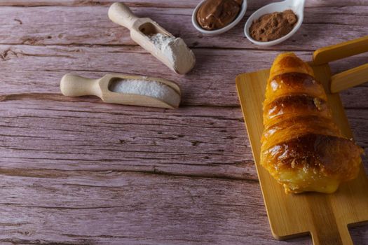 cream-filled puff pastry horn on a wooden board
