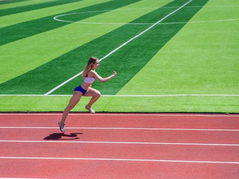 Young caucasian woman is engaged in jogging at the stadium outdoors