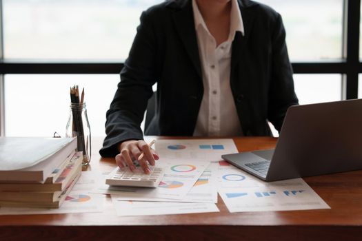 Business woman using calculator to audit the company's financial.