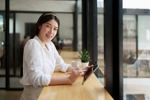 Freelance concept. Business woman using digital tablet at cafe.