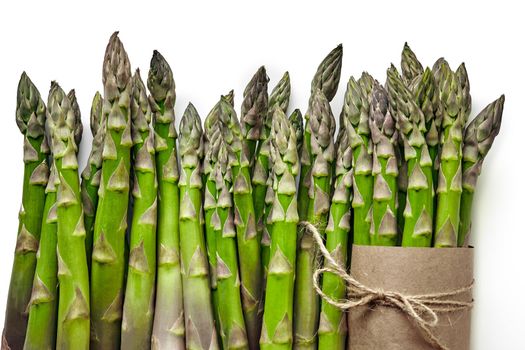 Bunch of an edible, raw sprouts of asparagus isolated on white background. Green vegetables, top view. Healthy food. Spring harvest, agricultural farming concept.