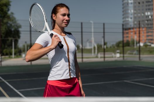 Beautiful smiling woman with a shadow from a tennis racket on her face on a sunny day.