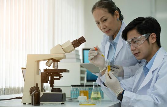 Asian scientists work in hospital pharmacology science research lab. Woman medical scientist and researchers teamwork analyzing innovative virus protective vaccines in health care biology laboratory.