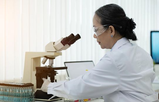 a doctor working in a research laboratory Science senior woman doing drug experiments. Chemistry concept, medicine, biochemistry, biotechnology. and health care.