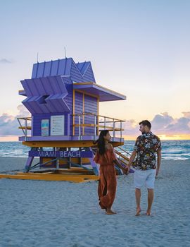 Miami Beach, a couple on the beach at Miami Florida, lifeguard hut Miami Asian women and caucasian men on the beach during sunset