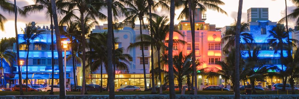 Miami Beach April 2019, colorful Art Deco District at night. Miami Beach Ocean Drive hotels and restaurants at sunset. City skyline with palm trees at night. Art deco nightlife on South beach