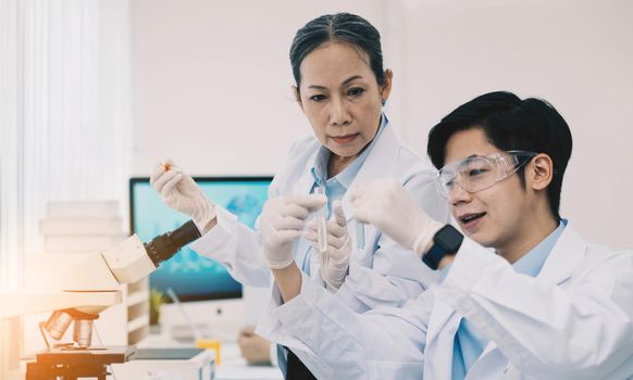 Asian scientists work in hospital pharmacology science research lab. Woman medical scientist and researchers teamwork analyzing innovative virus protective vaccines in health care biology laboratory.