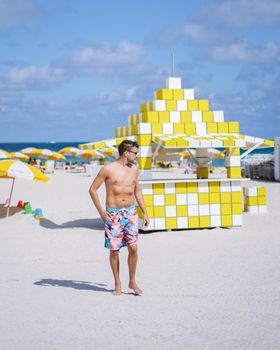 Miami beach, young men on the beach, lifeguard hut Miami beach Florida. caucasian men on the beach during sunset. European men shirtless with swim short