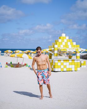 Miami beach, young men on the beach, lifeguard hut Miami beach Florida. caucasian men on the beach during sunset. European men shirtless with swim short