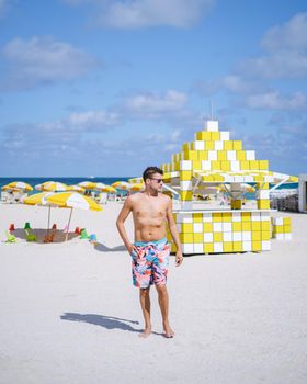 Miami beach, young men on the beach, lifeguard hut Miami beach Florida. caucasian men on the beach during sunset. European men shirtless with swim short