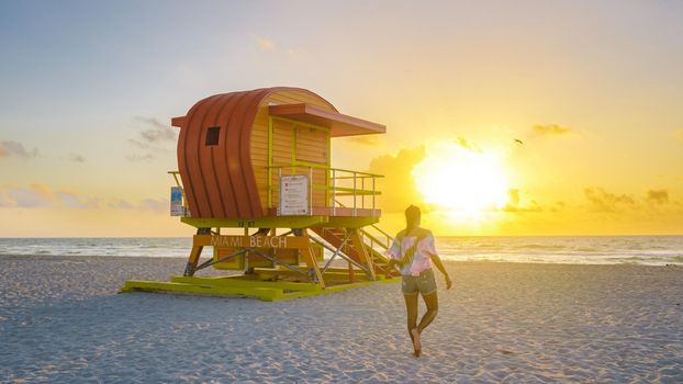 South Beach Miami Florida, beach hut lifeguard hut during sunset. beautiful sunset on Miami Beach. Young men walking on the beach during sunset