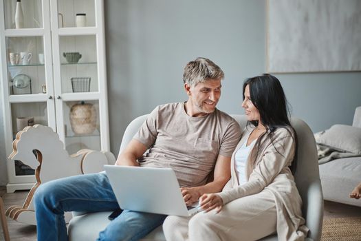 husband and wife using a laptop in their living room. close-up.